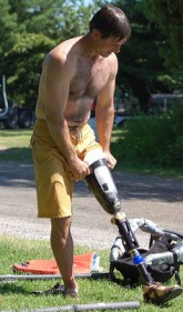 [ A participant adjusts his prosthetic "water leg". ]